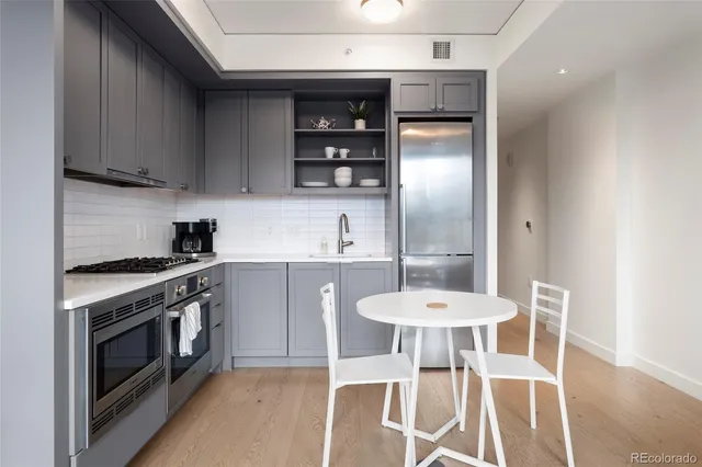 a kitchen with stainless steel appliances a dining table and chairs