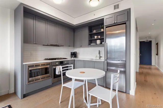 a kitchen with stainless steel appliances granite countertop a stove a refrigerator and a dining table