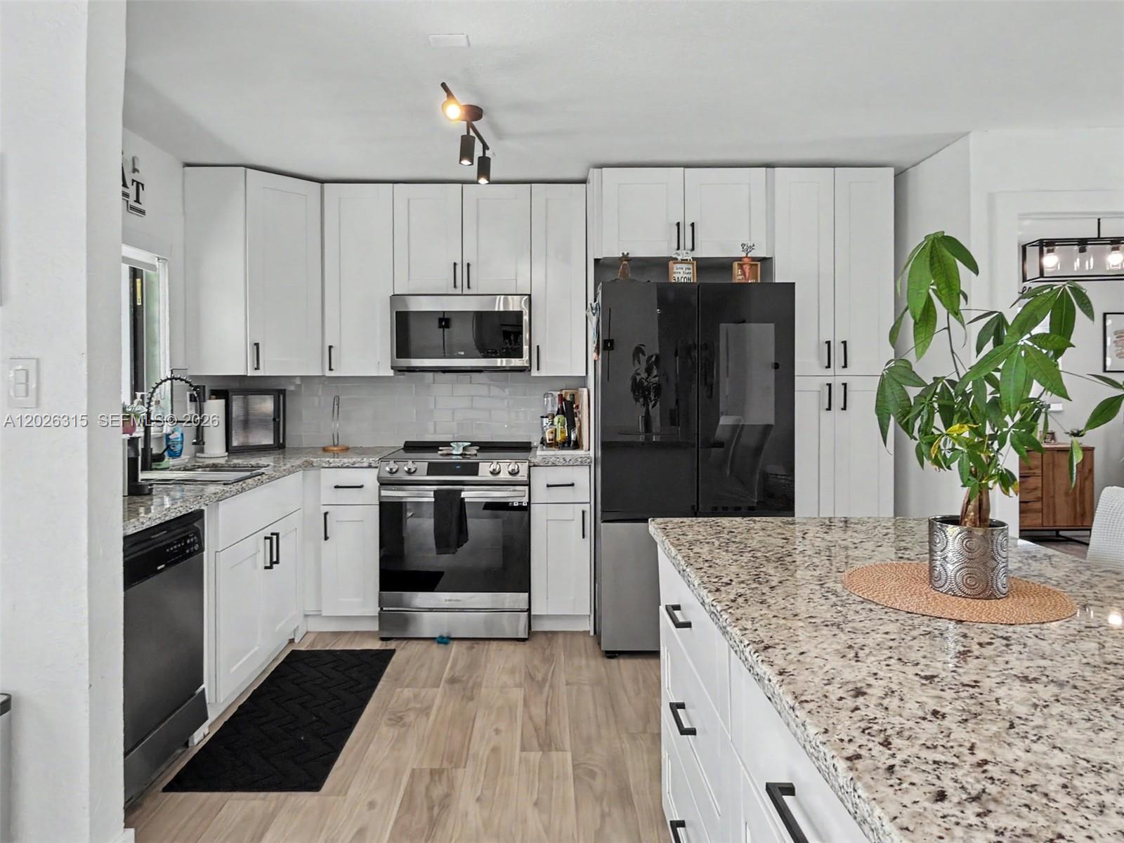 10762 Southwest 145th Street Miami, FL 33176 - Photo 9 of 28 a kitchen with a refrigerator and a stove top oven