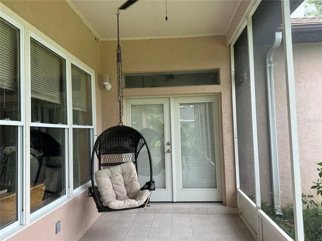 a view of a white house with a big yard and large trees