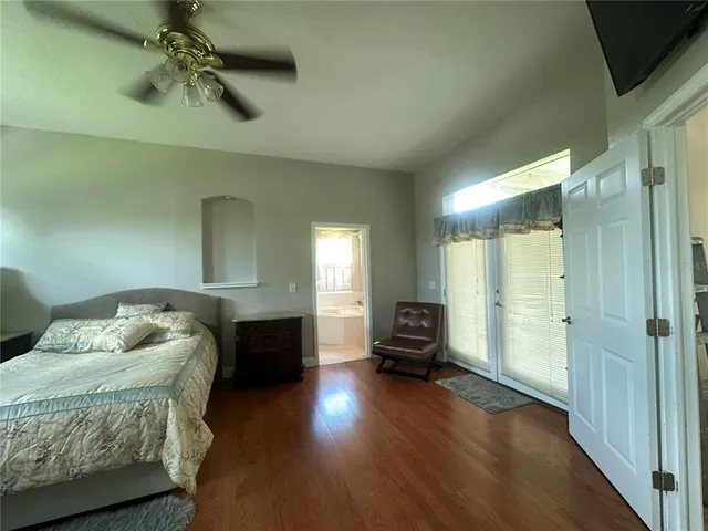 a green field with lots of trees in the background