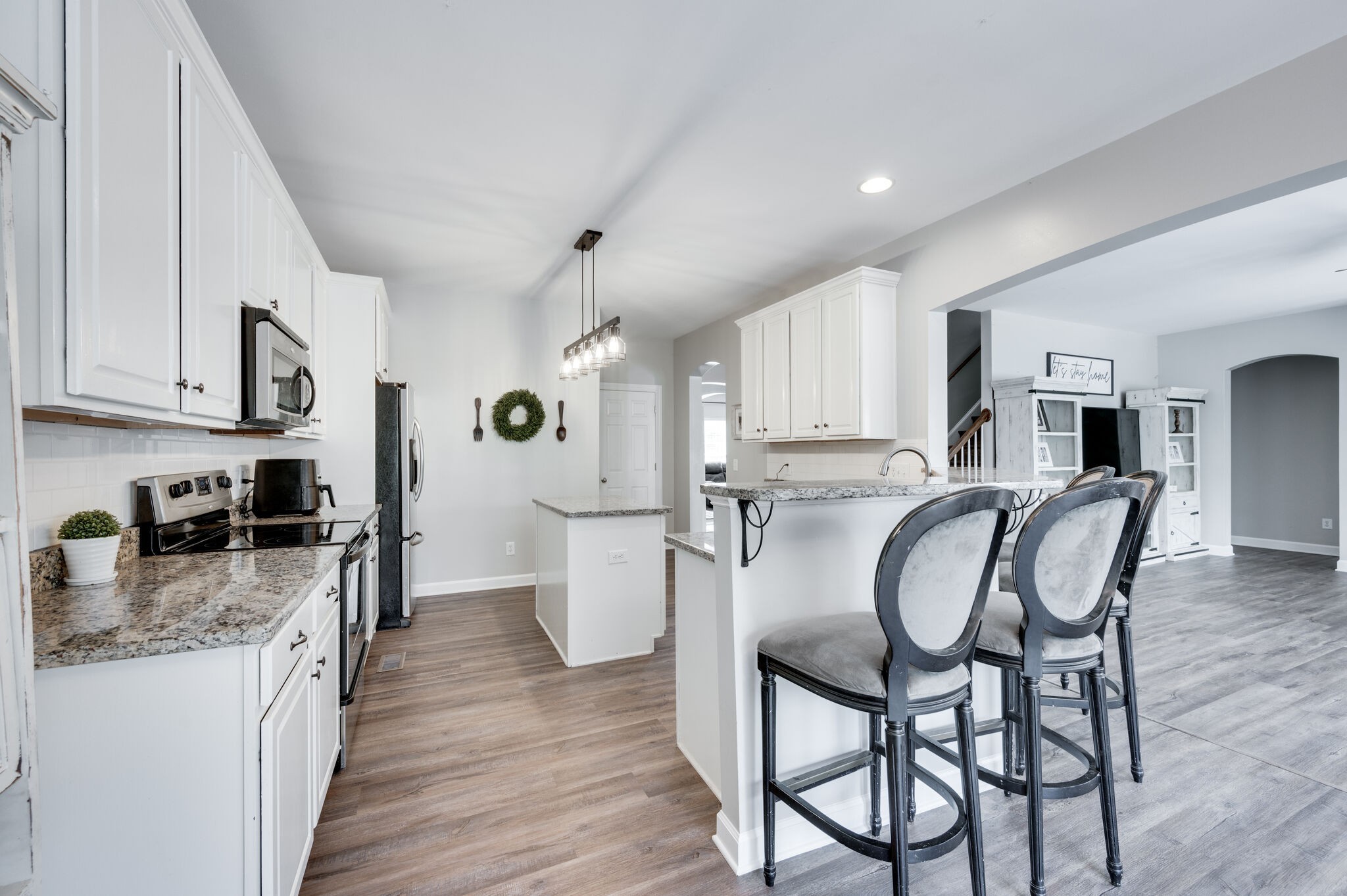 2047 Belshire Way Spring Hill, TN 37174 - Photo 22 of 54 a kitchen with stainless steel appliances kitchen island granite countertop a refrigerator a stove a sink a dining table and chairs with wooden floor