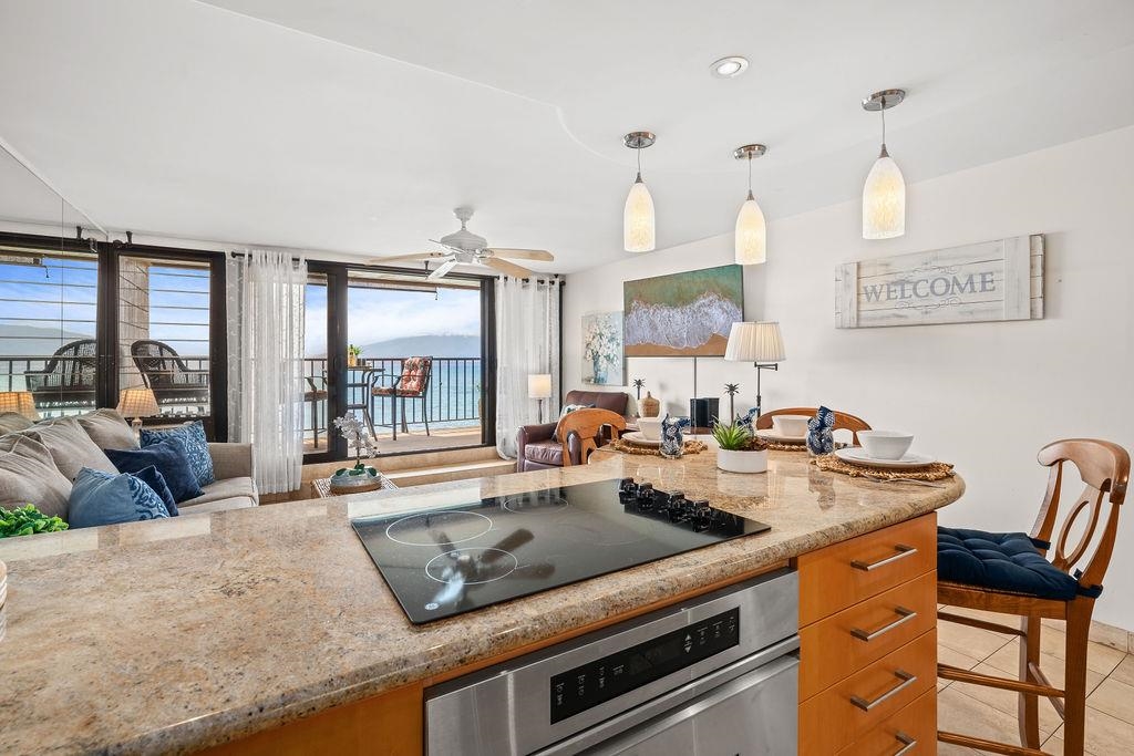 3785 Lower Honoapiilani Road, Unit 208 Lahaina, HI 96761 - Photo 8 of 50 a kitchen with stainless steel appliances granite countertop a sink a stove and a living room view