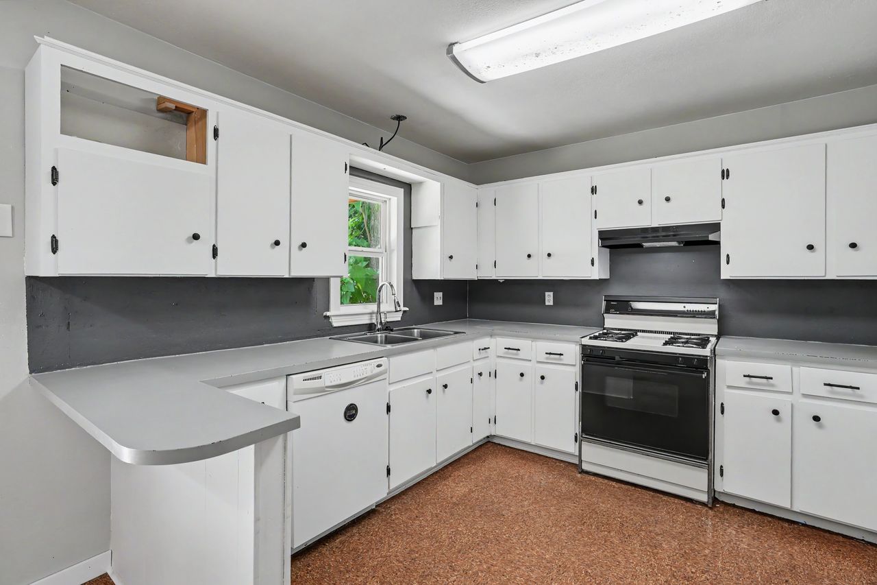 1811 Terry Lane Georgetown, TX 78628 - Photo 11 of 40 A well-equipped kitchen features ample white cabinetry, a convenient breakfast bar, and essential appliances.