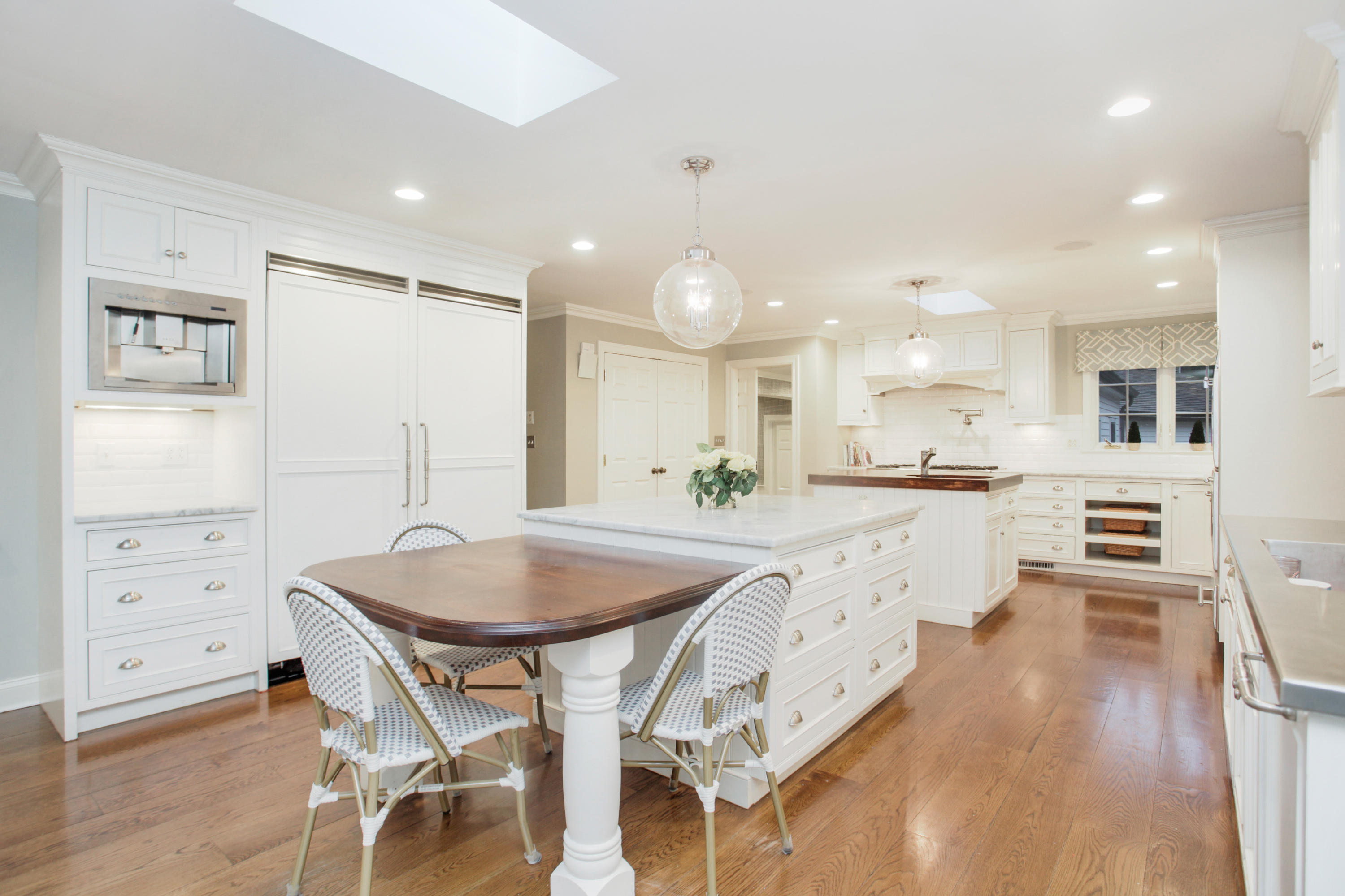 6 Hummingbird Lane Darien, CT 06820 - Photo 10 of 35 a large kitchen with kitchen island a island a stove a sink a dining table and chairs