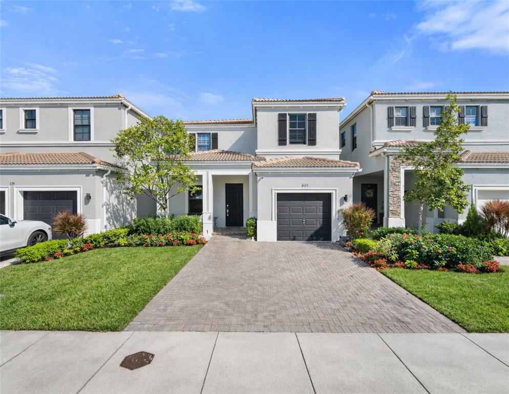 a front view of a house with yard and green space