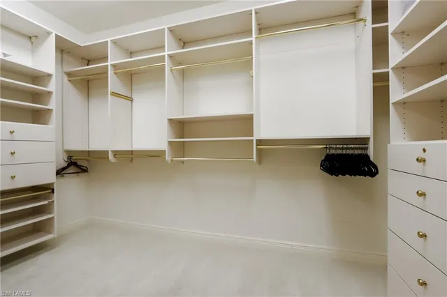 a view of walk in closet with clothes and shoes