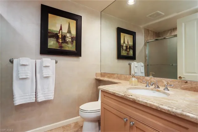 a bathroom with a granite countertop toilet a sink and mirror