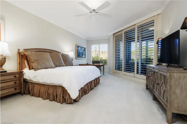 a spacious bedroom with a bed and a flat screen tv