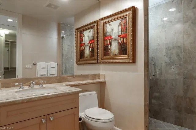a bathroom with a granite countertop sink mirror and toilet