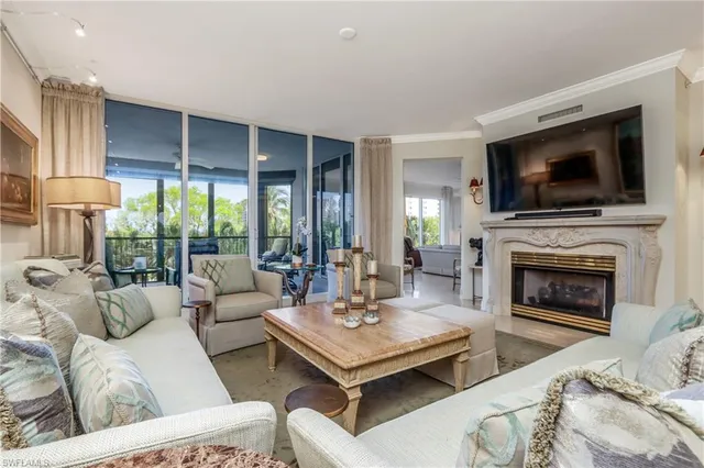 a living room with furniture a flat screen tv and a fireplace