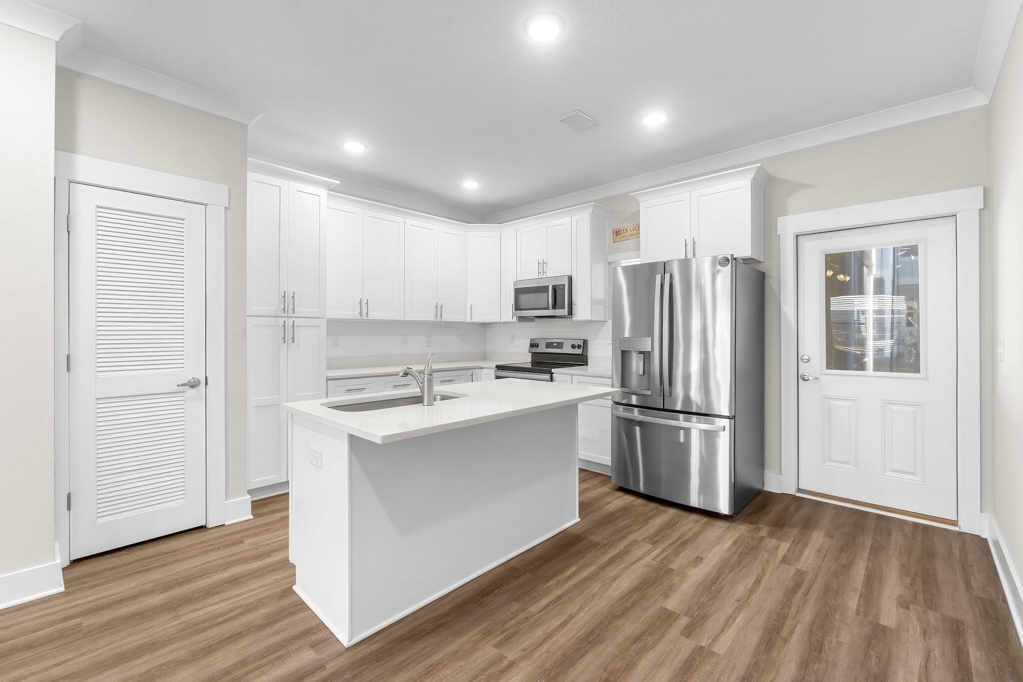 330 North Sand Palm Road, Unit VISTA Freeport, FL 32439 - Photo 12 of 38 a kitchen with a refrigerator a sink and dishwasher with wooden floor