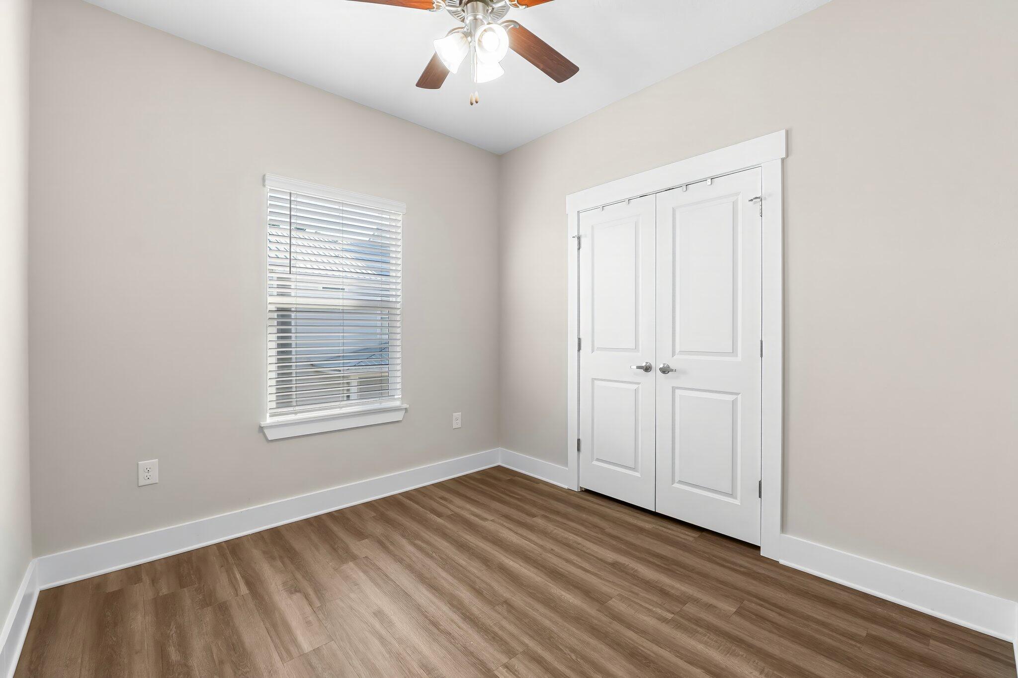 330 North Sand Palm Road, Unit VISTA Freeport, FL 32439 - Photo 25 of 38 an empty room with wooden floor chandelier fan and windows