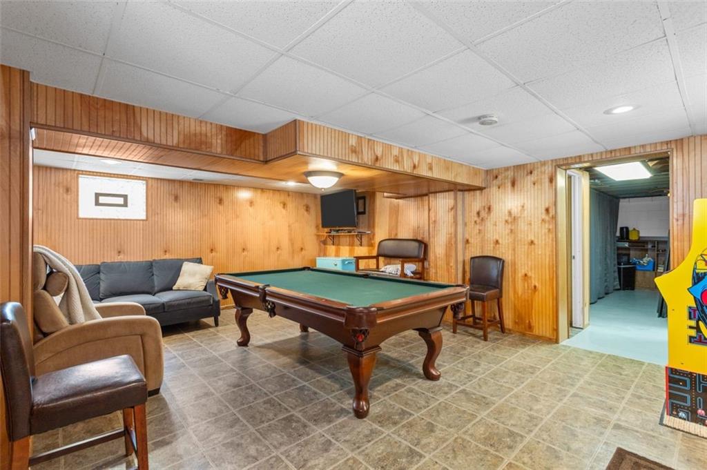 812 Rolling Rock Road Pittsburgh, PA 15234 - Photo 21 of 24 Large finished game room with wooden bead board on the walls, ceramic tile floor and powder room located next to it.