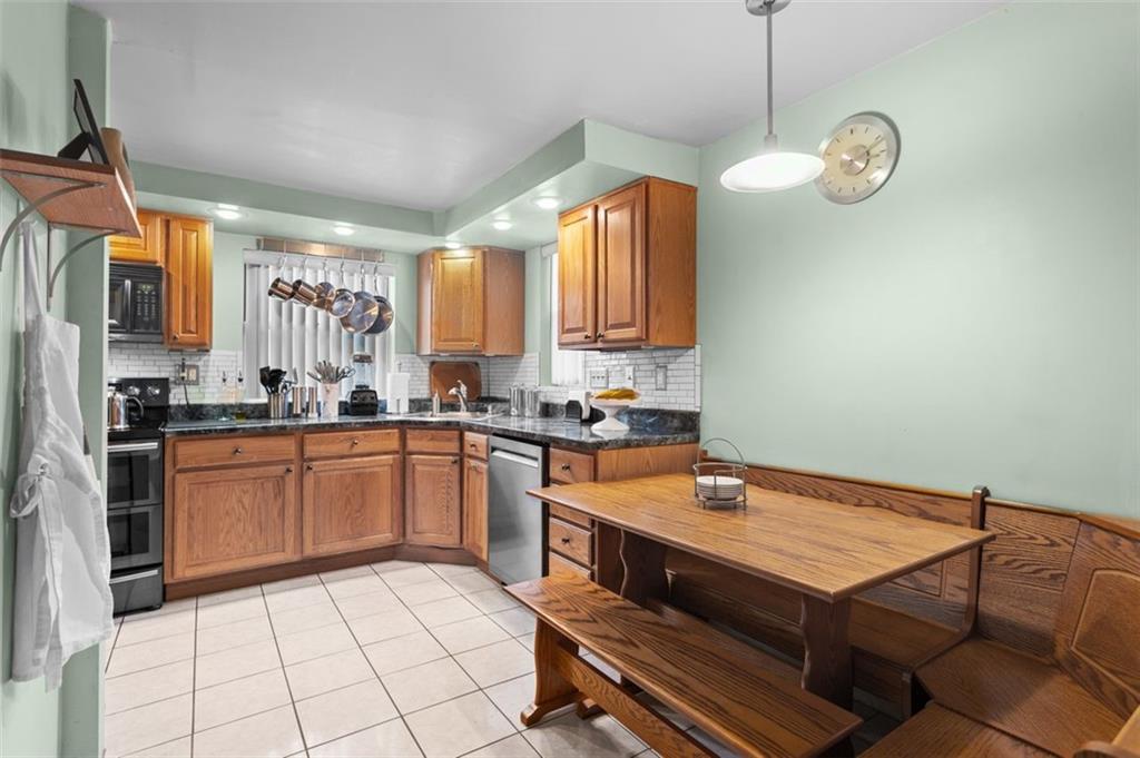 812 Rolling Rock Road Pittsburgh, PA 15234 - Photo 7 of 24 Also to the left a little further up from the living room is the kitchen. Notice the custom-made oak table, surround seating and bench. Wooden oak cabinets with granite countertops. SS appliances and ceramic tile floor.