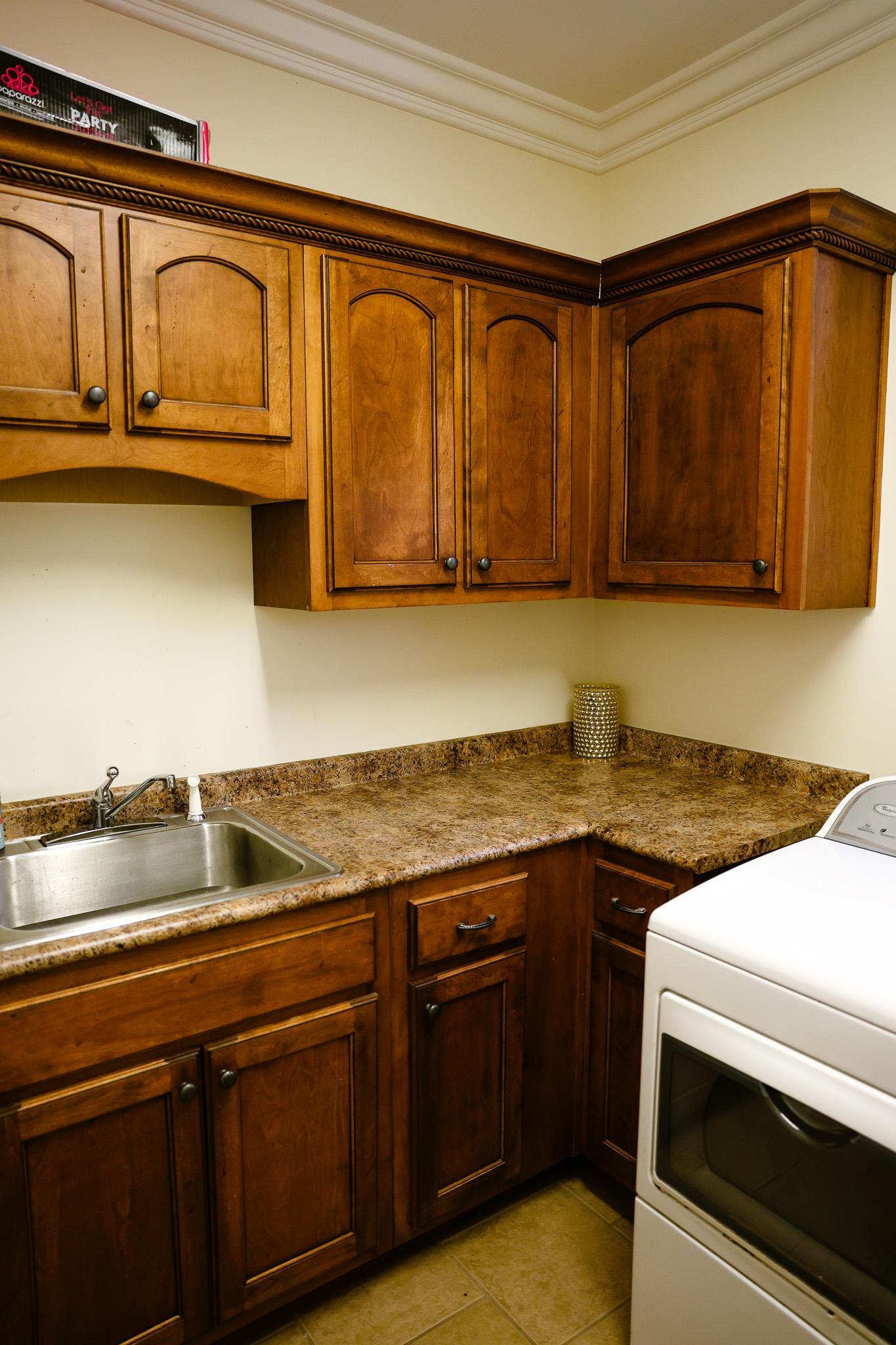 649 Ridge Springs Road Collierville, TN 38017 - Photo 26 of 35 Laundry area with washer / clothes dryer, crown molding, cabinet space, and light tile patterned flooring