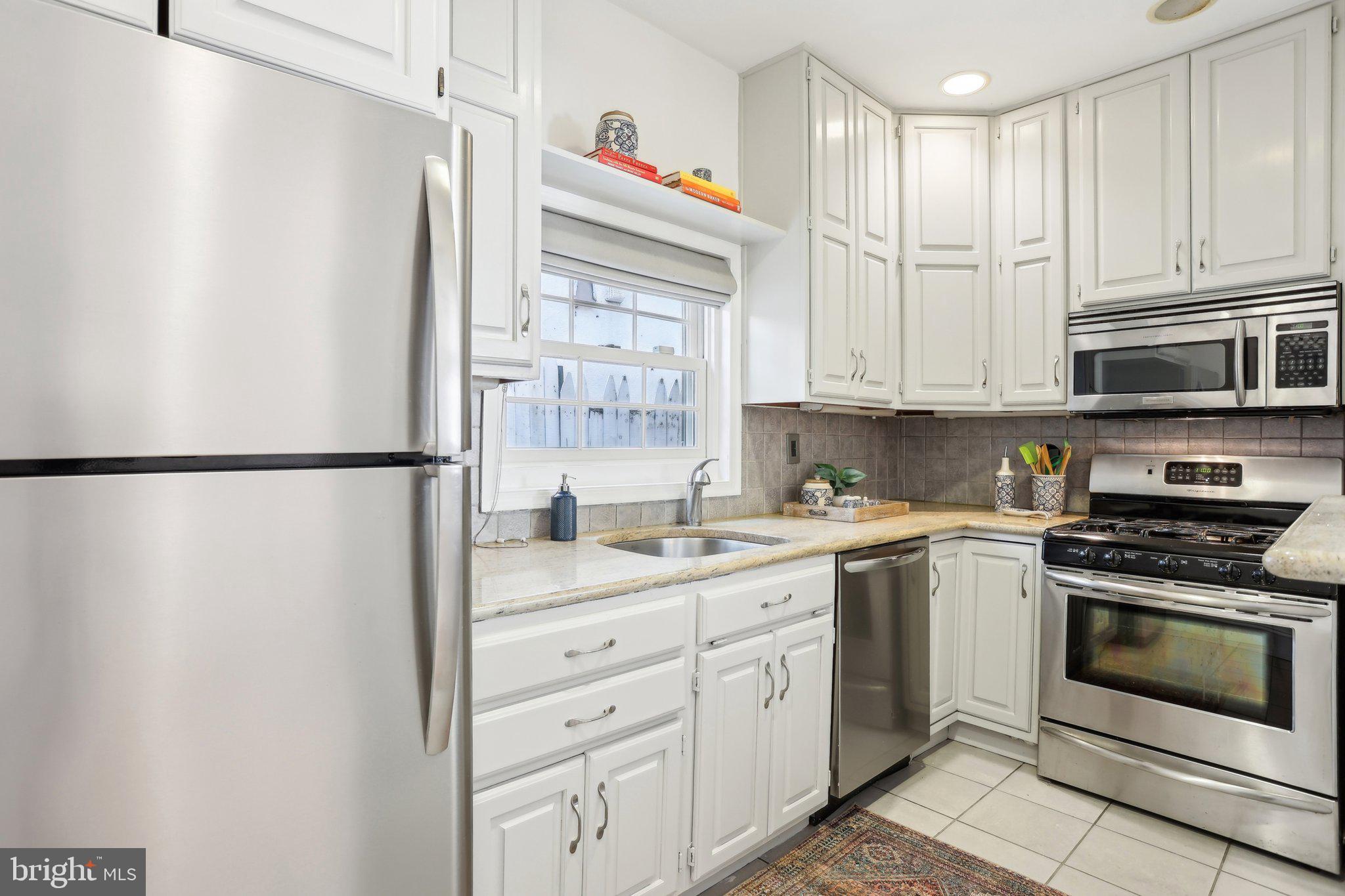 321 South Smedley Street Philadelphia, PA 19103 - Photo 10 of 39 a kitchen with stainless steel appliances granite countertop a refrigerator a stove a sink and white cabinets