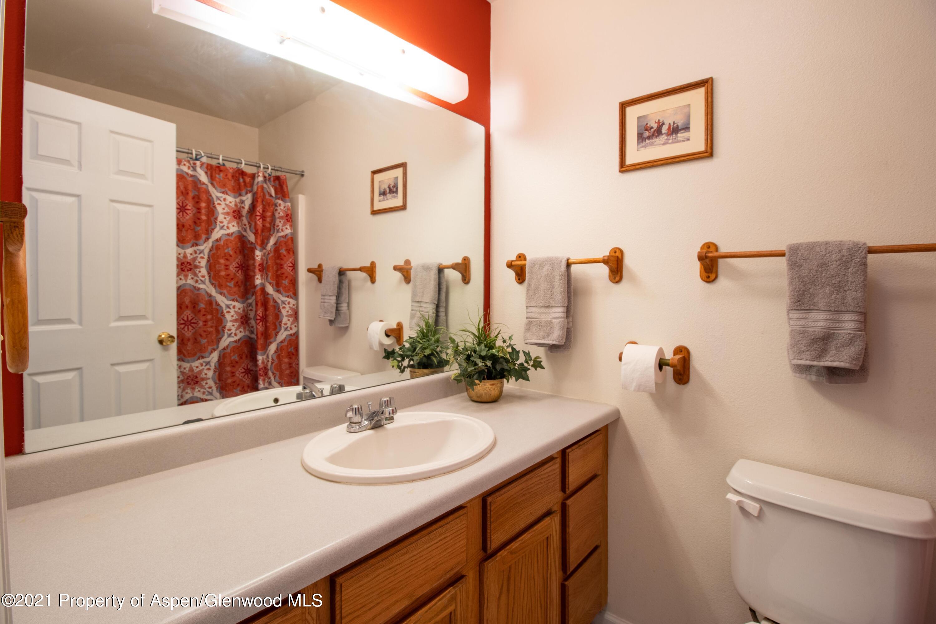 444 Lind Avenue Rifle, CO 81650 - Photo 4 of 13 a bathroom with a sink vanity mirror and toilet