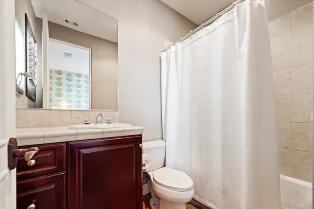 a spacious bedroom with a large bed and a chandelier