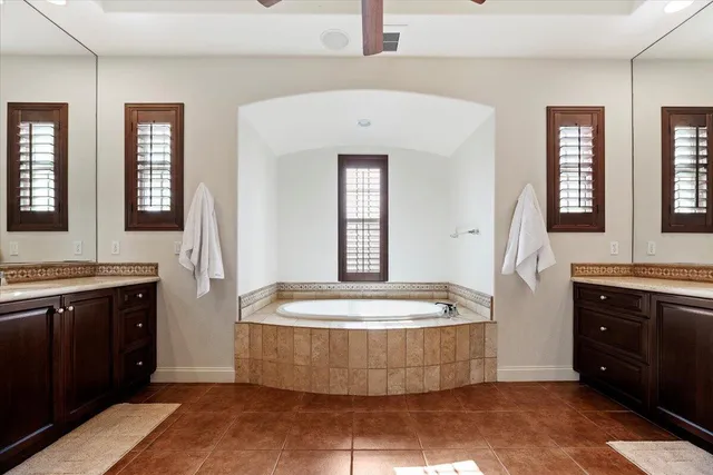 a spacious bathroom with a granite countertop sink a mirror and a shower