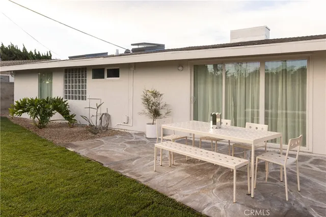 a view of a house with a patio and a yard