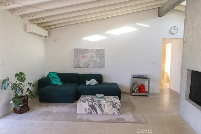 a view of a hallway with kitchen island stainless steel appliances refrigerator and fireplace