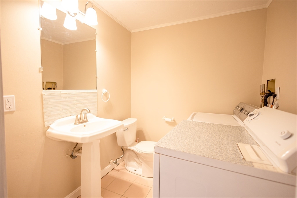 5337 B Washington Street, Unit B Boston, MA 02132 - Photo 13 of 41 a bathroom with a sink a toilet and mirror