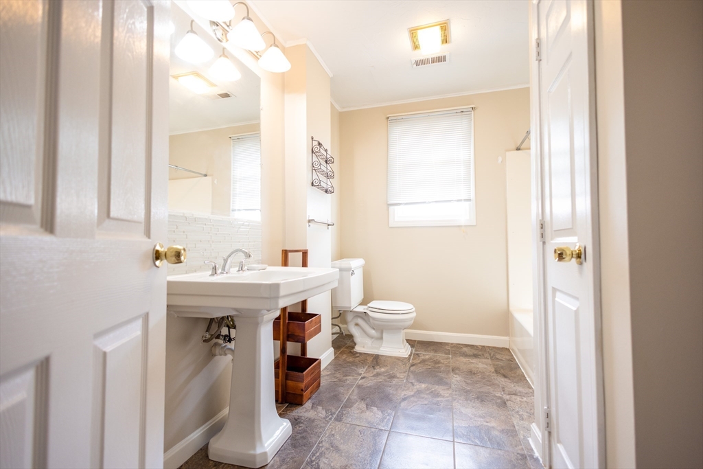 5337 B Washington Street, Unit B Boston, MA 02132 - Photo 17 of 41 a bathroom with a sink a toilet and a mirror