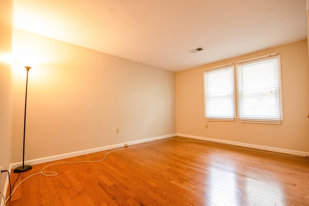 5337 B Washington Street, Unit B Boston, MA 02132 - Photo 25 of 41 a view of an empty room with wooden floor and a window