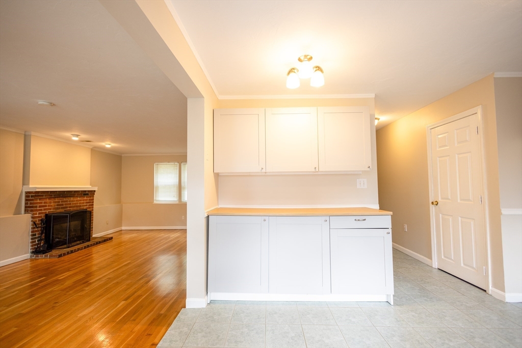5337 B Washington Street, Unit B Boston, MA 02132 - Photo 29 of 41 a view of a kitchen with wooden cabinet and a fireplace