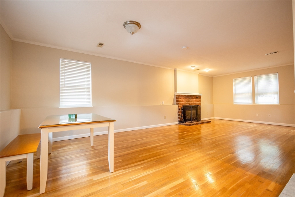 5337 B Washington Street, Unit B Boston, MA 02132 - Photo 6 of 41 a view of a livingroom with wooden floor and fireplace
