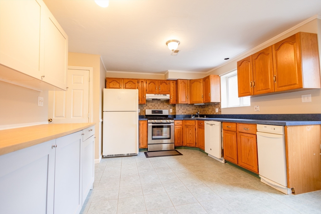 5337 B Washington Street, Unit B Boston, MA 02132 - Photo 9 of 41 a kitchen with stainless steel appliances granite countertop a refrigerator and sink