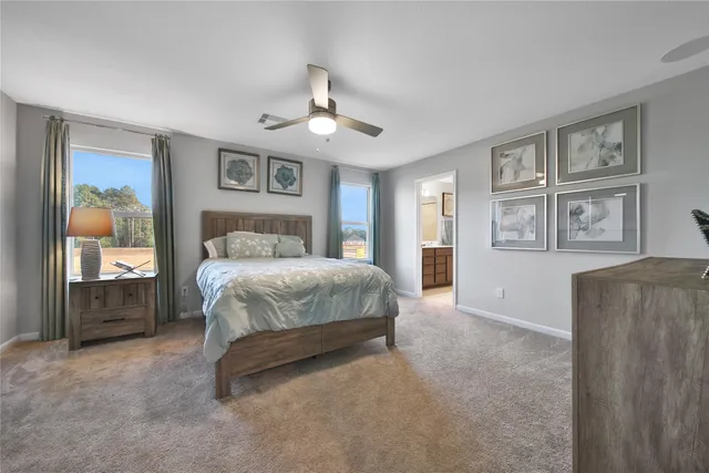 a spacious bedroom with a large bed and a chandelier