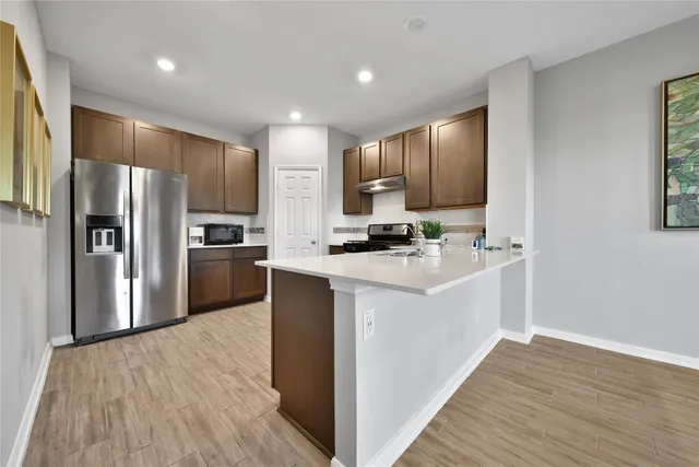 a kitchen with kitchen island a refrigerator sink and cabinets