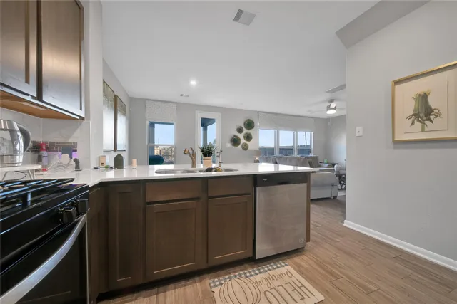 a kitchen with stainless steel appliances granite countertop a sink stove and cabinets