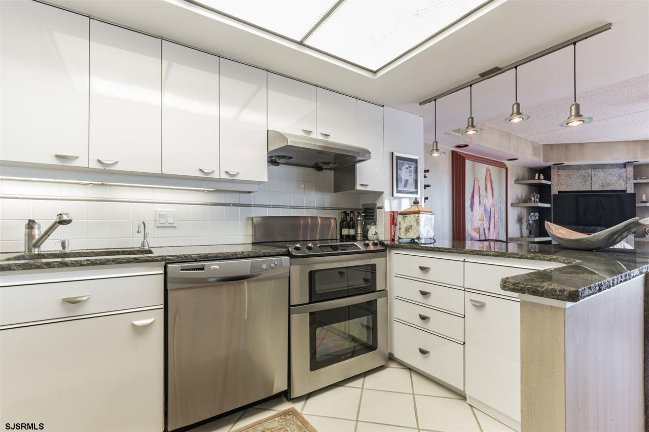 2700 Atlantic Avenue, Unit 419 Longport, NJ 08403 - Photo 12 of 32 a kitchen with stainless steel appliances granite countertop a stove a sink and a refrigerator