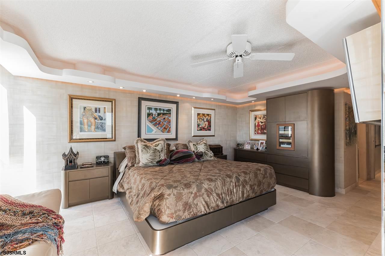 2700 Atlantic Avenue, Unit 419 Longport, NJ 08403 - Photo 19 of 32 a bedroom with a large bed and a chandelier