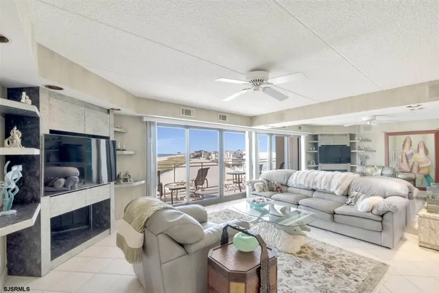 a living room with furniture a flat screen tv and a large window