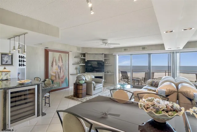 a living room with furniture a flat screen tv and kitchen view