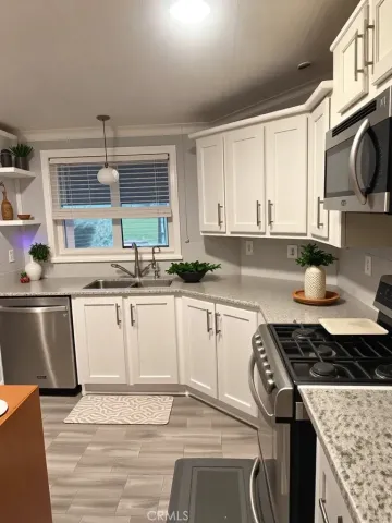 a kitchen with stainless steel appliances granite countertop a stove a sink and a microwave