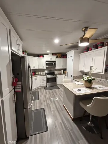 a kitchen with stainless steel appliances kitchen island a refrigerator sink and wooden cabinets