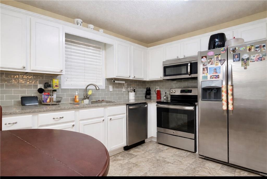 132 Sydney Summit Villa Rica, GA 30180 - Photo 7 of 20 a kitchen with stainless steel appliances granite countertop a sink a stove a microwave and cabinets