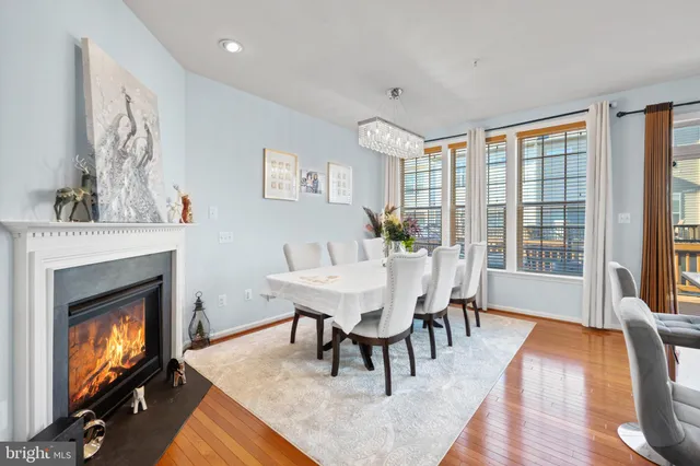 a dining room with furniture a fireplace and wooden floor