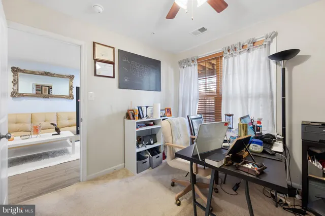 a view of a livingroom with workspace and a window