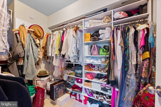 a view of walk in closet with clothes and shoes