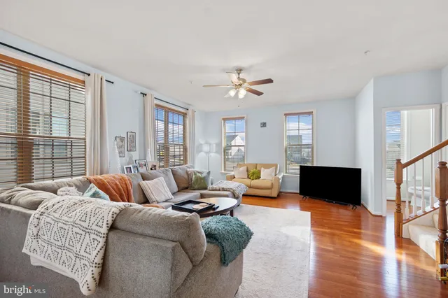 a living room with furniture ceiling fan and a window