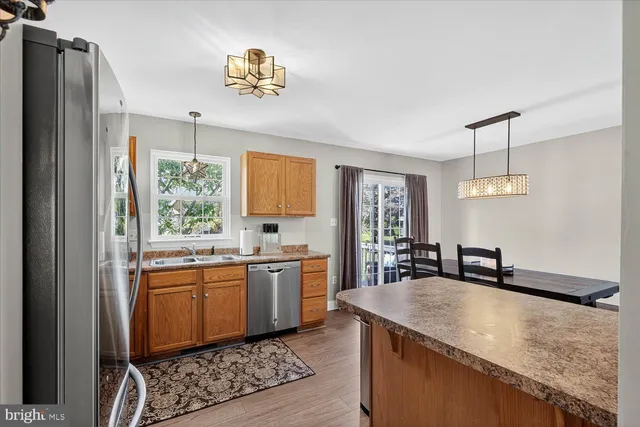 a kitchen with granite countertop a sink stainless steel appliances and white cabinets