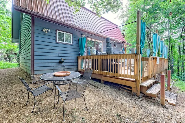 a view of a backyard with table and chairs and a swimming pool