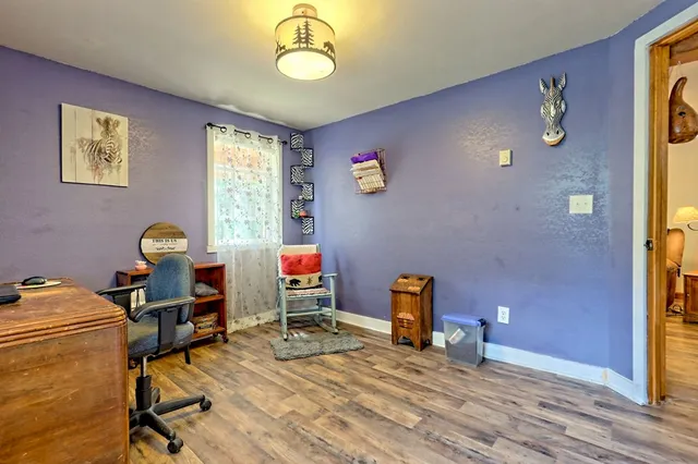 a kitchen with stainless steel appliances granite countertop a stove top oven a sink dishwasher a dining table and chairs with wooden floor