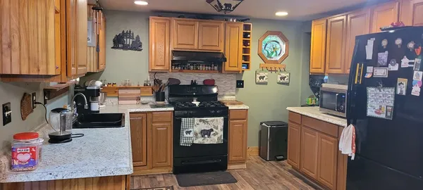 a kitchen with stainless steel appliances granite countertop a stove a sink and a refrigerator